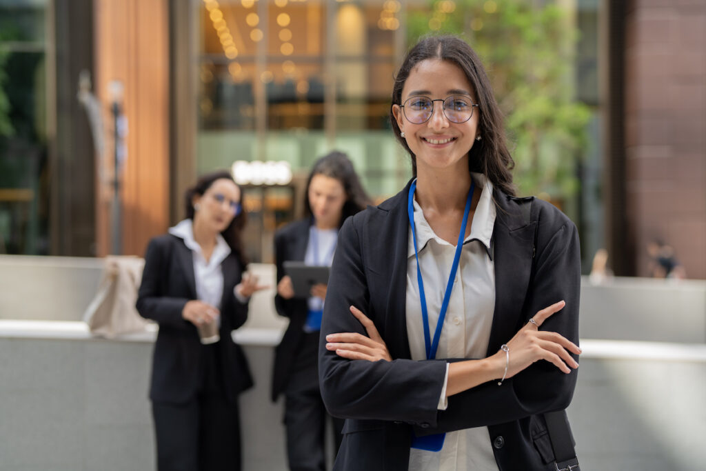 A young business professional standing confidently near an urban office building setting